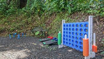 Uma área de exercícios ao ar livre, com uma parede de exercícios azul e laranja, um banco de metal e uma mesa.