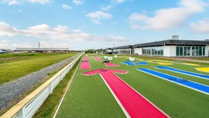 Un campo sportivo con diverse piste di atletica e un edificio sullo sfondo.