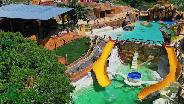 A water park with slides, pools, and a small building. - Hotel pekin (San Carlos)