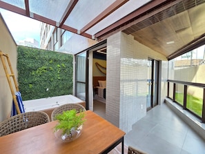 A modern interior with a wooden table, a potted plant, and a view of the outside. - SEASON Smart Flats by BLU stay (Ipojuca)