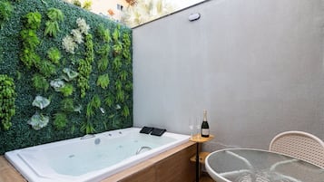 Uma área de spa com hidromassagem, uma mesa de vidro e uma cadeira.