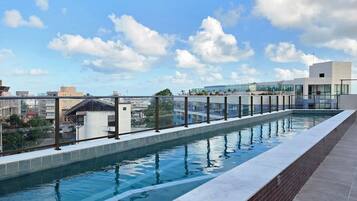 Piscina no terraço com vista ampla da paisagem urbana.