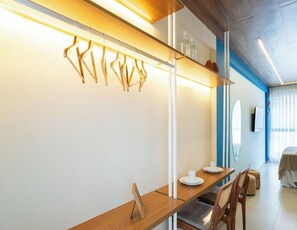 Un'area pranzo moderna con un tavolo e sedie in legno, un lampadario e uno scaffale a parete con bottiglie di vetro.