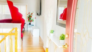A modern living room with a red chair, a white sofa, and a wooden staircase. - Spacious 4BR Rockville Yard, BBQ & Free Parking (Rockville)