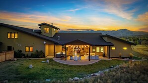 A modern house with a patio area, stone walls, and a view of mountains. - Park City Lighthouse| Mountain View, Hot Tub & BBQ (Park City)