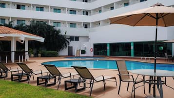 Una piscina al aire libre, tumbonas