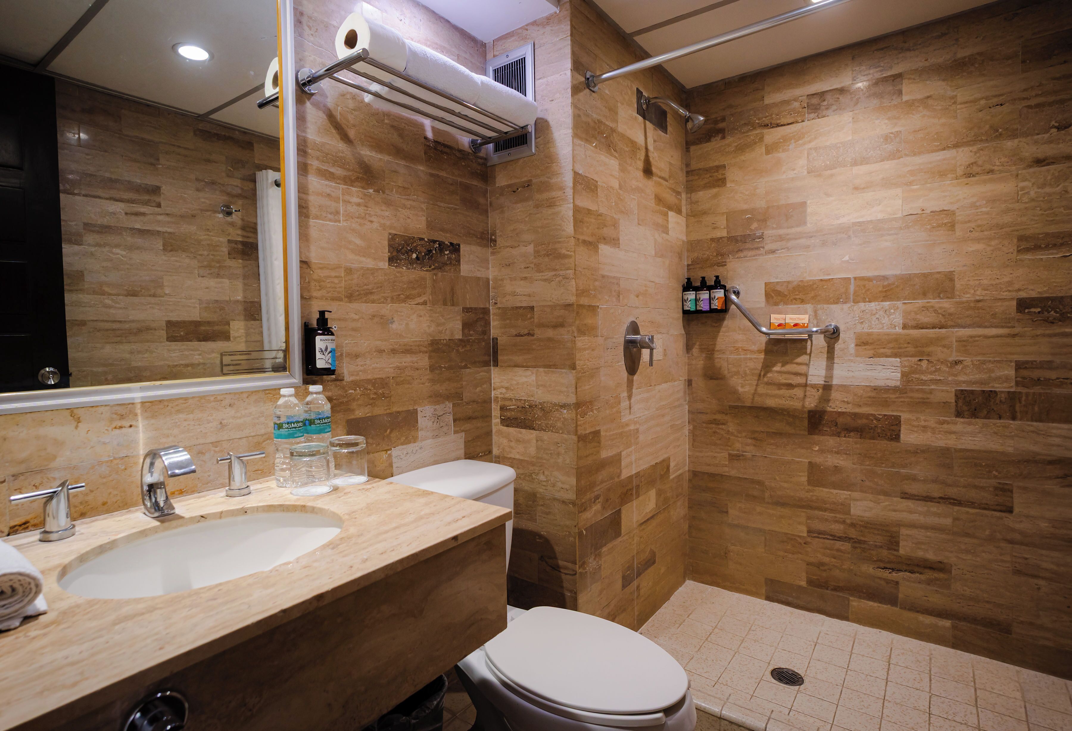 A bathroom with a sink, toilet, and shower area.