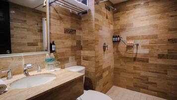 A bathroom with a sink, toilet, and shower area.