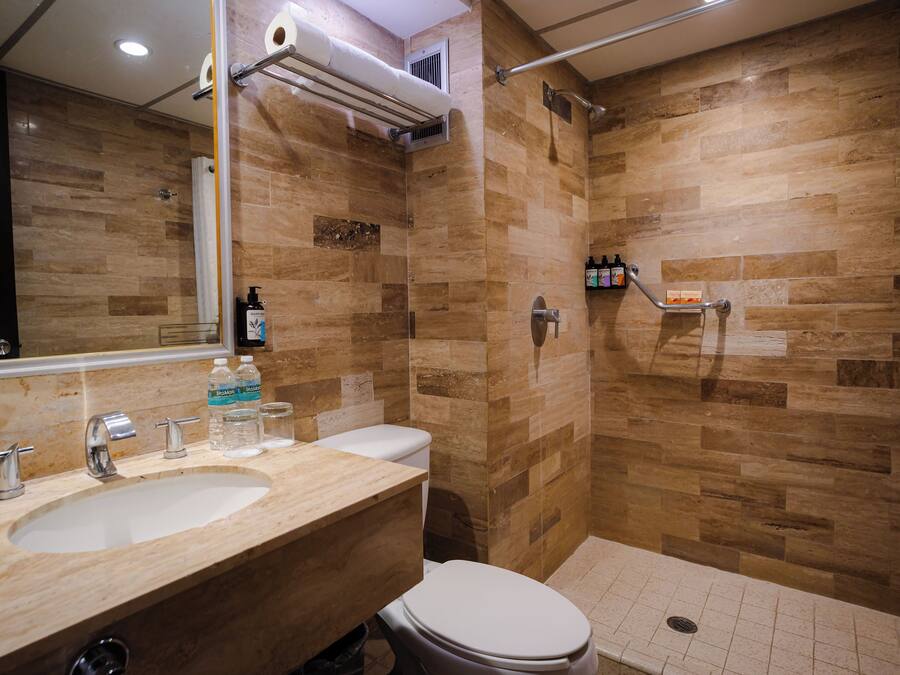 A bathroom with a sink, toilet, and shower area.