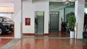 A building entrance with a fire hose reel, a staircase, and an elevator. - Cozy 1BR condo with hardwood floors and rooftop sunset garden in Phnom Penh (Phnom Penh)
