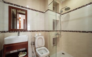 Une salle de bain avec un lavabo, des toilettes et une douche.