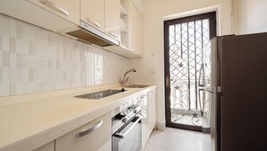 Una cucina moderna con lavello in acciaio inossidabile, forno a incasso e frigorifero.