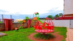 Un parque infantil con columpios, tobogán y estructura para escalar.