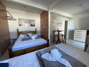 A hotel room with a bed, a small table, a chair, and a dresser. - Estação Do Mar  (Florianópolis)