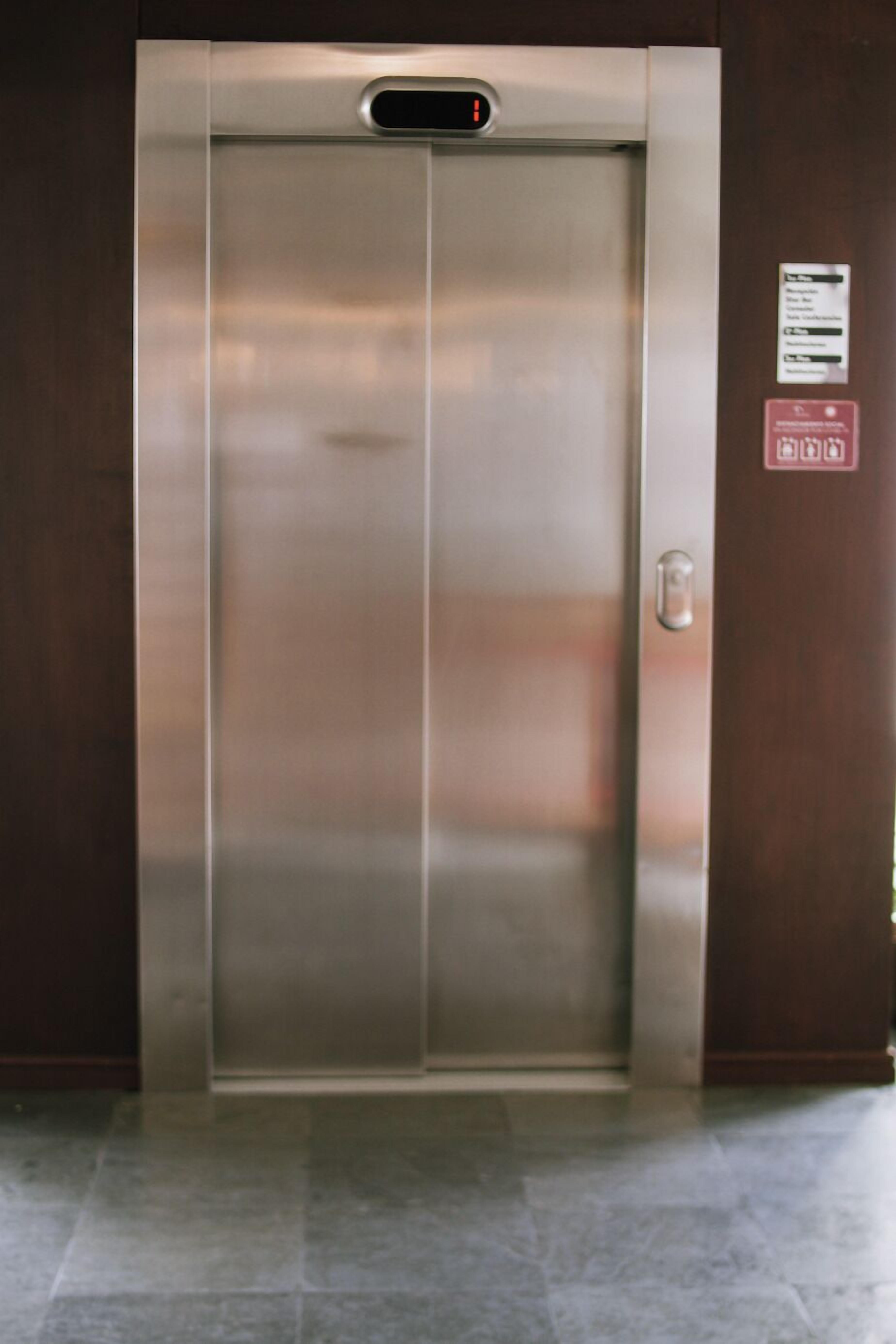 Een moderne lift met een digitaal scherm aan de bovenkant.