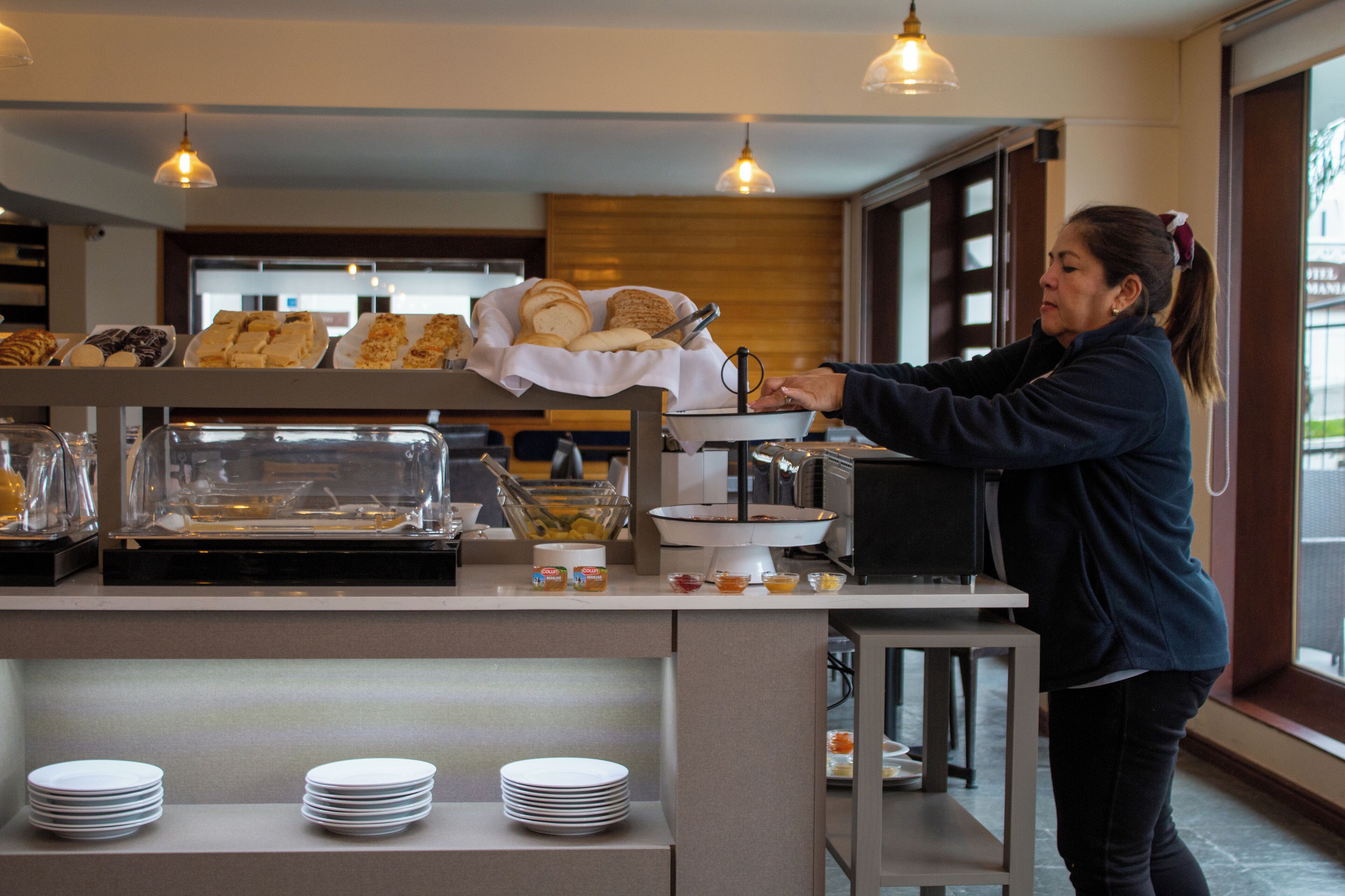 A buffet setup with various food items and a person serving.
