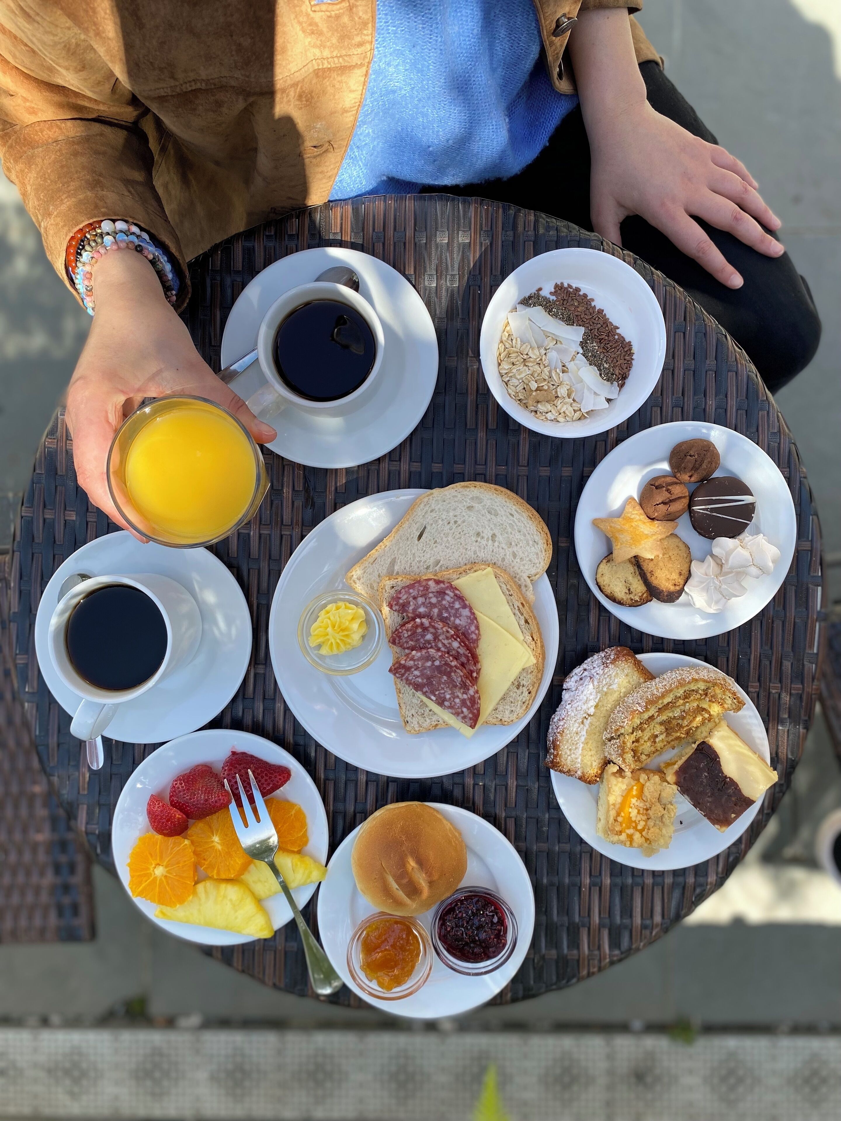 A table with various breakfast items including coffee, toast, pastries, and fruit.