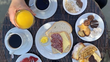 A table with various breakfast items including coffee, toast, pastries, and fruit.
