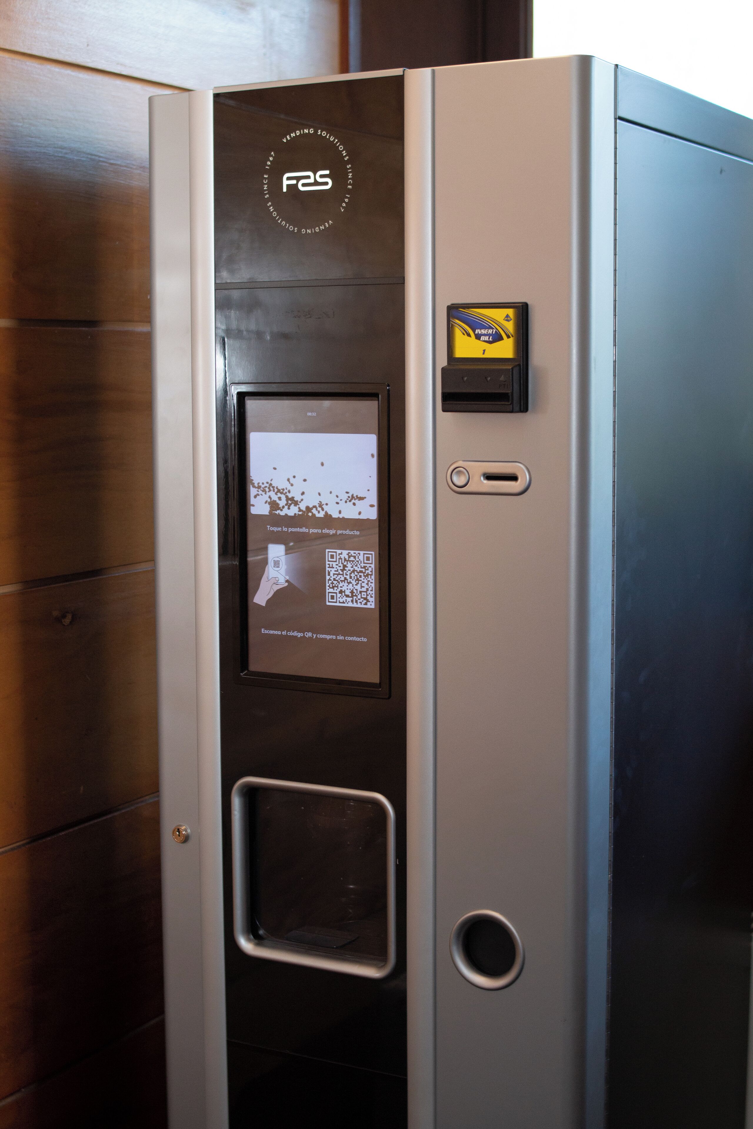 A self-service kiosk with a QR code for product information, a payment terminal, and a small display screen.