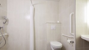A bathroom with a shower, toilet, and grab bars. - B B Hotel Tours Centre Commercial La Petite Arche Hotel (Tours)