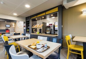 A B&B hotel breakfast area with tables, chairs, and a coffee machine. - B B Hotel Tours Centre Commercial La Petite Arche Hotel (Tours)