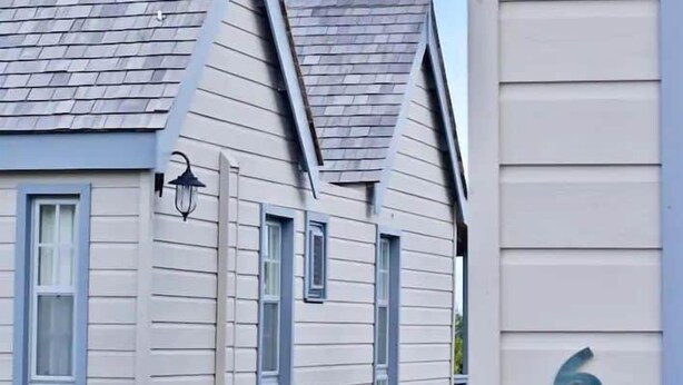 Een rij huizen met puntgevels en het nummer '6' op de gevel.