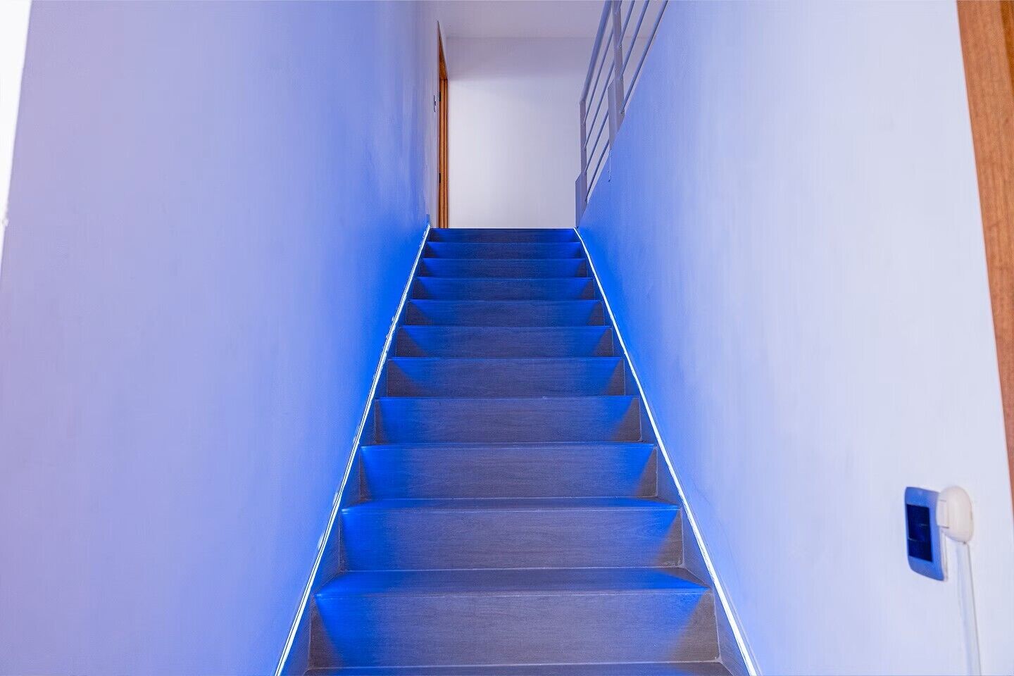 Eine Treppe mit blau beflasterten Stufen, die zu einer Zwischenebene führen.