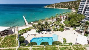 A resort with a swimming pool, beach, and ocean view.