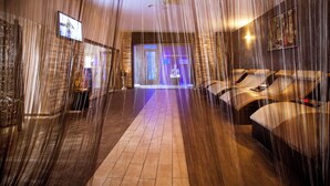A spa area with a long corridor, a reception desk, and massage chairs.