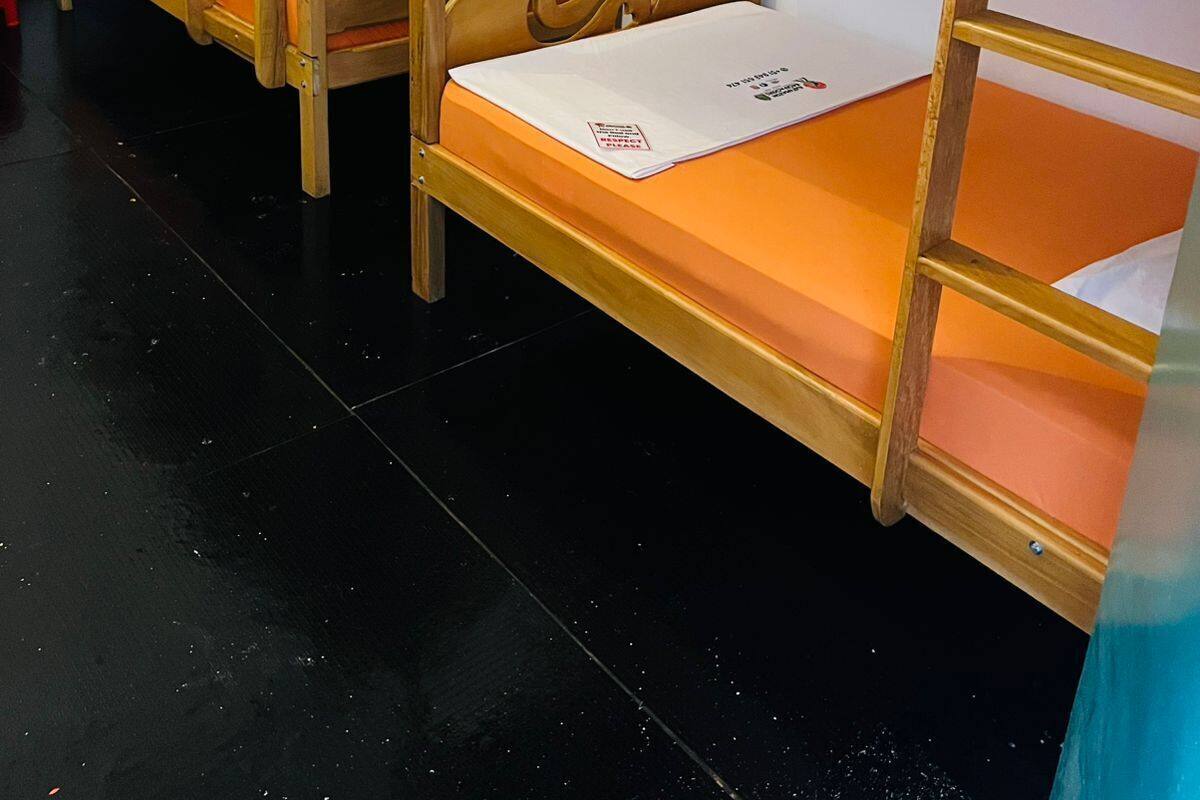 Bunk beds with wooden frames and orange mattresses.