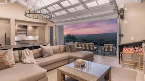 A spacious living area with a large sofa, a coffee table, and a view of the outdoors. - Vineyard Views w/ Pool & Game Room Near Trails, Wineries Beginnings Ranch & Vineyard by Avantstay (Paso Robles)