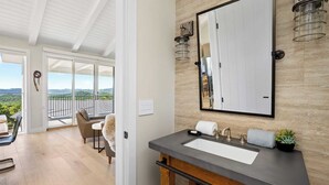 A bathroom with a large mirror, a modern sink, and a view of the outdoors. - Vineyard Views w/ Pool & Game Room Near Trails, Wineries Beginnings Ranch & Vineyard by Avantstay (Paso Robles)