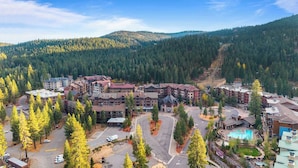 A resort with multiple buildings, a central parking area, and a mountainous backdrop. - Cozy Northstar Village Escape w/ Forest Views & Easy Lift Access Alpineglow Vista by Avantstay (Truckee)