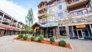 A building with multiple floors, a stone facade, and a sign for 'Copper Lane Provisions'. - Cozy Northstar Village Escape w/ Forest Views & Easy Lift Access Alpineglow Vista by Avantstay (Truckee)