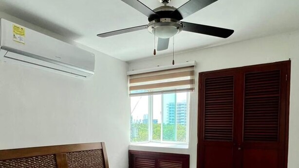 A bedroom with a bed, a ceiling fan, a window with blinds, and a door with louvered shutters. - Em3-1g 1 Bedroom Apartment in Residential Area air Conditioning and Wifi (Cartagena)