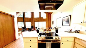 Una cocina con armarios de madera, una estufa y un comedor con sillas.