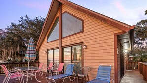 A wooden deck with outdoor furniture, including lounge chairs and a table. - 3-bedroom cabin in gorgeous Clermont with AC (Clermont)