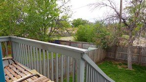 A wooden deck with a metal railing, surrounded by a wooden fence and trees. - Bright Arvada Townhome with Backyard, Walkable to Old Town Arvada (Arvada)