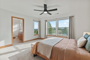 A bedroom with a bed, a ceiling fan, and large windows with curtains. - Bring a golf 4-some, family or couples. 4 private bed/baths- sleeps 10 (Redmond)