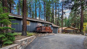 A cabin with a stone retaining wall, a wooden deck, and a garage. - Private Woods - Heavenly California Lodge (South Lake Tahoe)