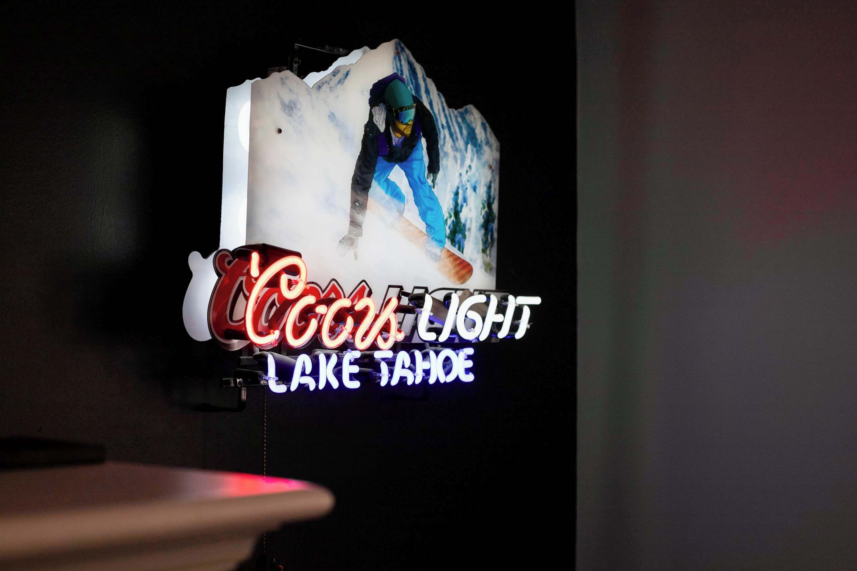 Un letrero de neón con un snowboarder y el texto "COCOA LIGHT LAKE TAHOE".
