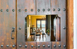 A rustic wooden door with a view of a dining area through a small window. - Awesome home in Villanueva del Rey (Villanueva del Rey)