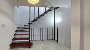 Un escalier au design moderne, avec une finition en bois et des rampes en métal noir.