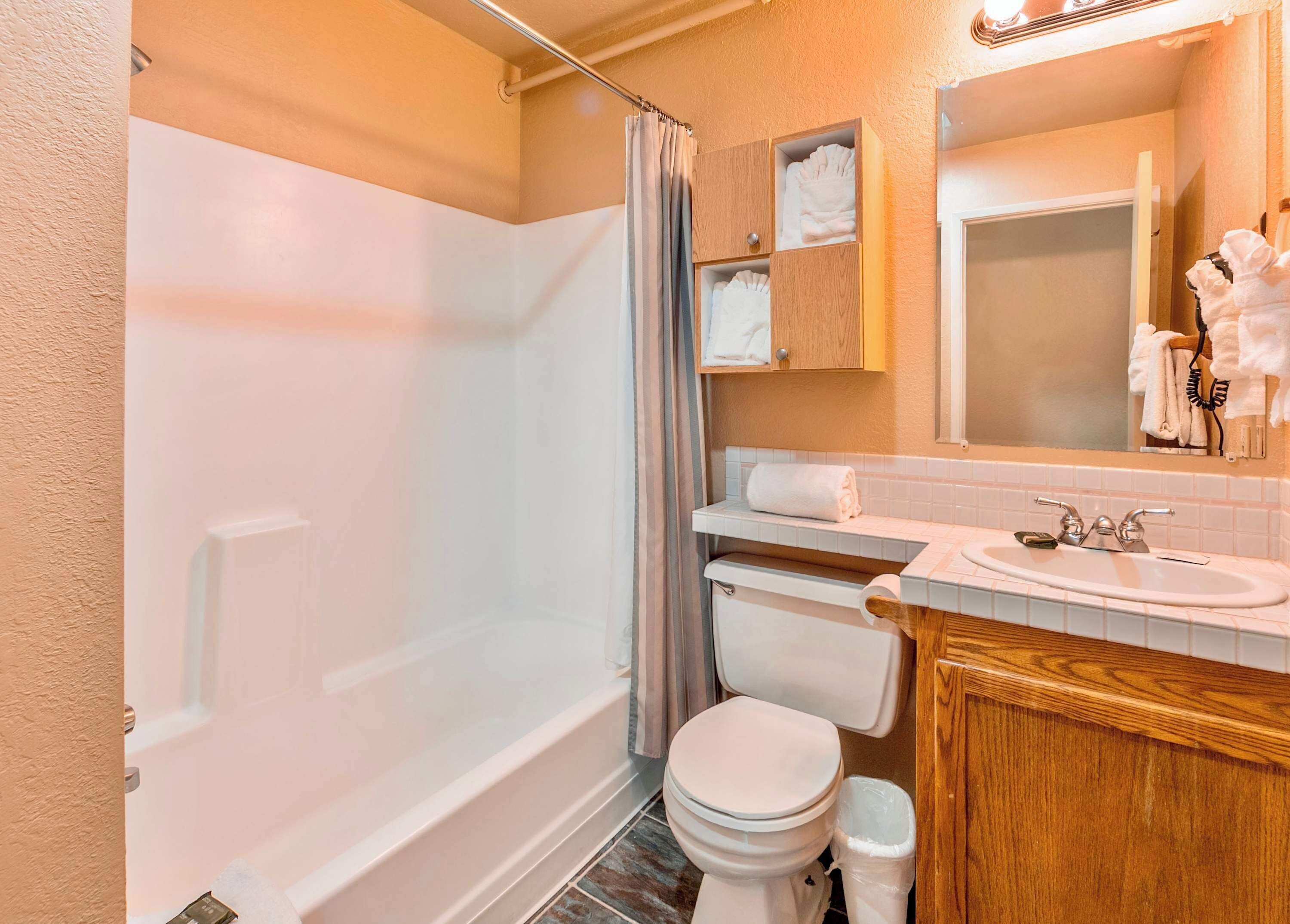 Une salle de bain équipée d’une baignoire, de toilettes, d’un lavabo et d’un miroir.