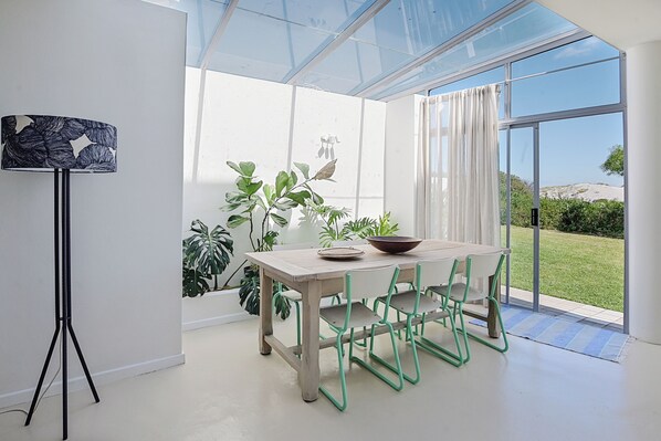 A modern dining area with a table, chairs, and a bowl.