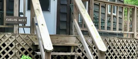 Eine Holztreppe führt zu einer Veranda, auf der ein Schild mit der Aufschrift 'Eagles Nest' steht.