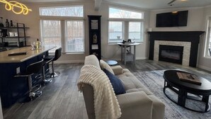 Ein geräumiges Wohnzimmer mit einer Couch, einem Couchtisch, einem Kamin und einer Bar.