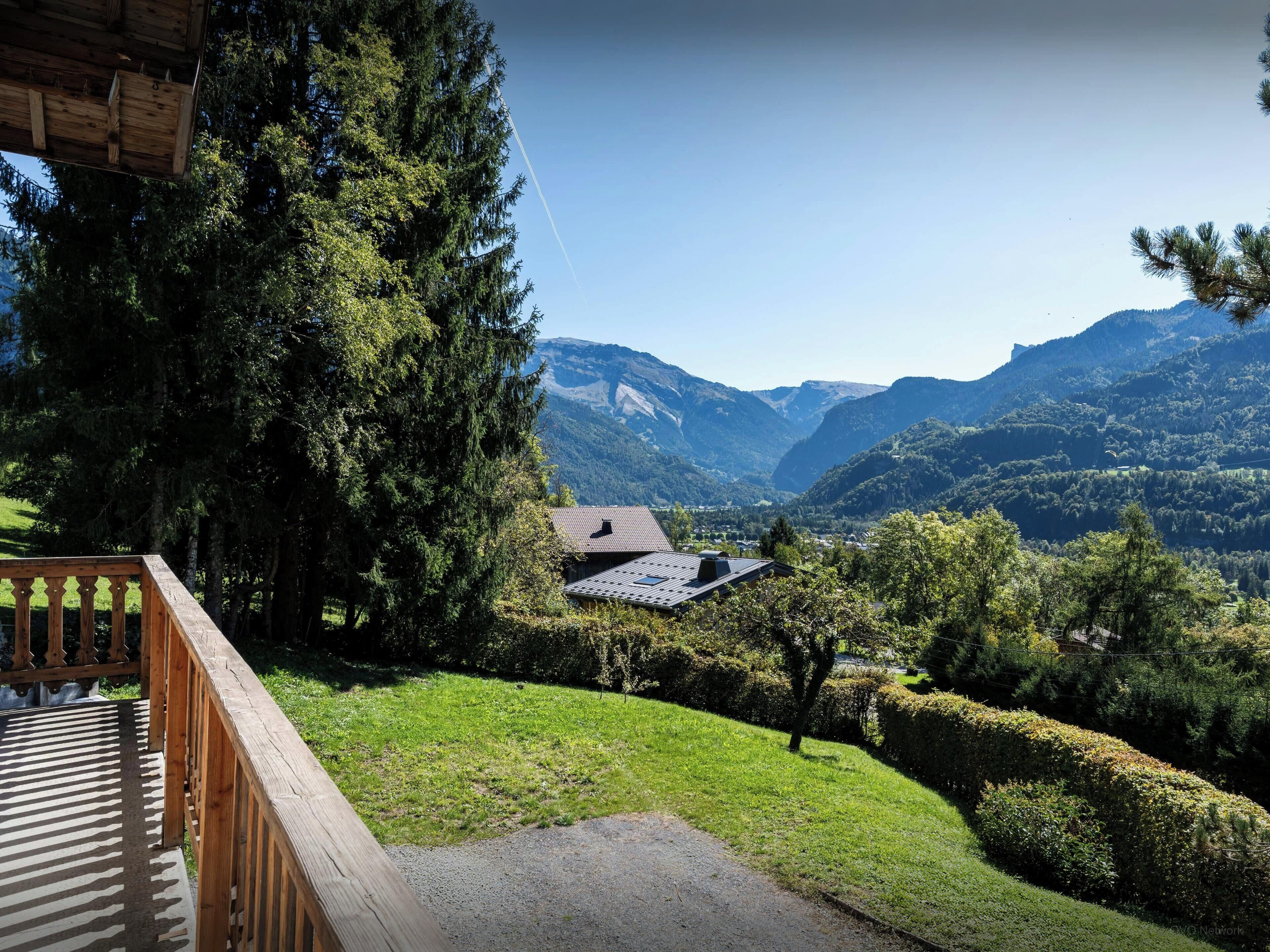 Una terraza de madera con vistas a un paisaje montañoso.