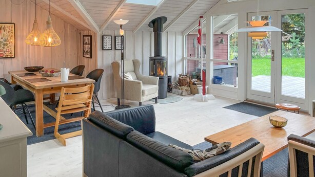 Un salón acogedor con chimenea, muebles de madera y ventanas amplias.