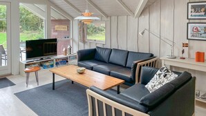 Una sala de estar moderna con un sofá, una mesa de centro y una televisión.